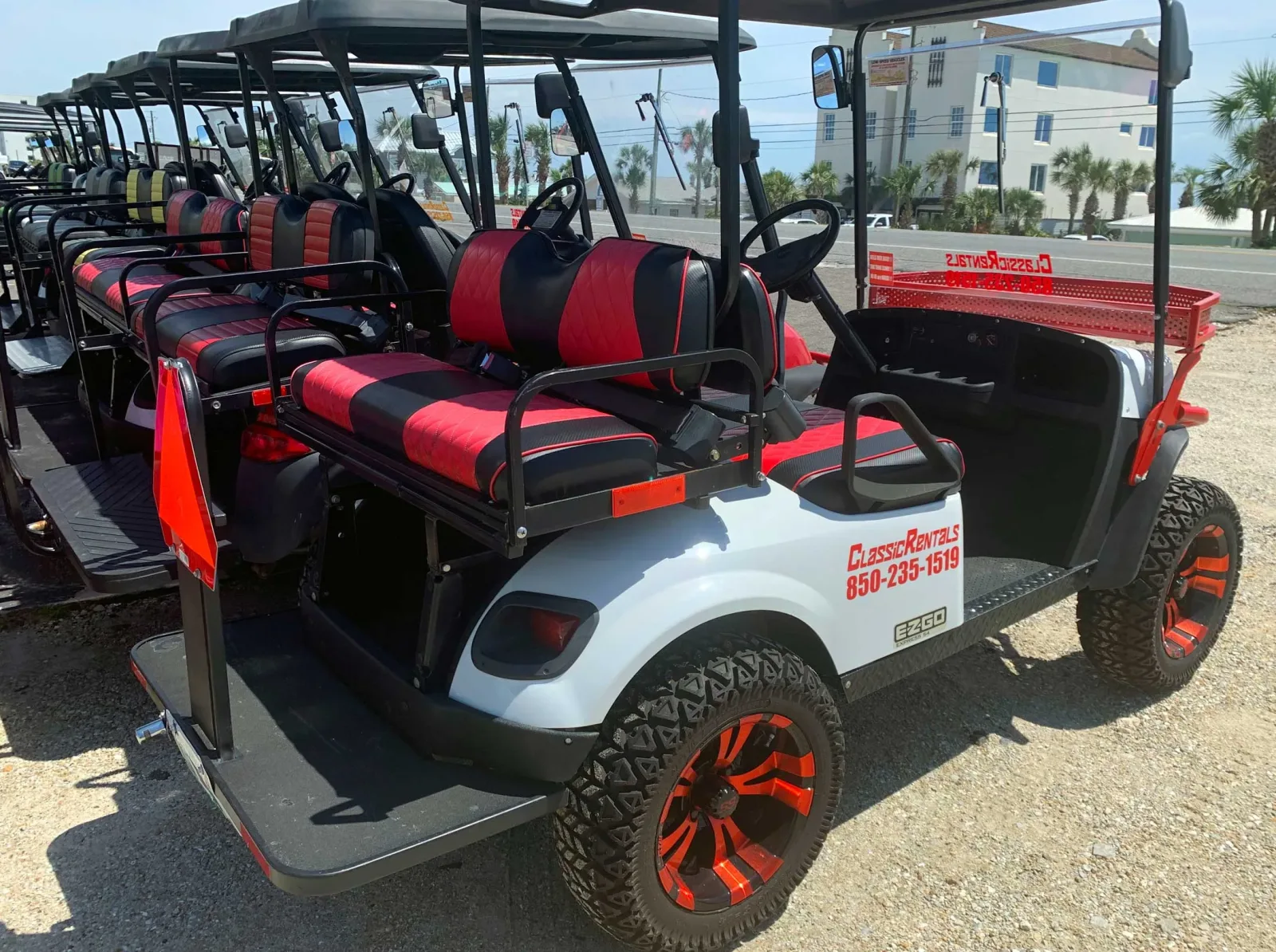 Row of Classic Rentals golf carts with red and black seats in Panama City Beach